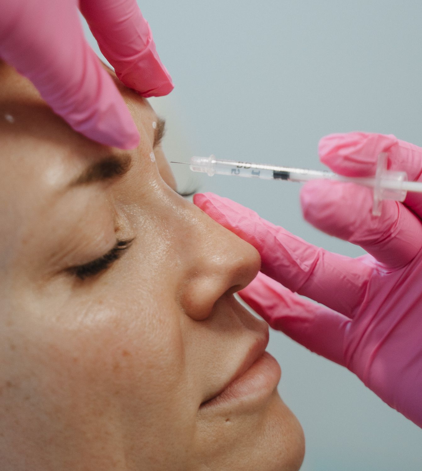 Crown Point Botox model wearing a white shirt holding her neck