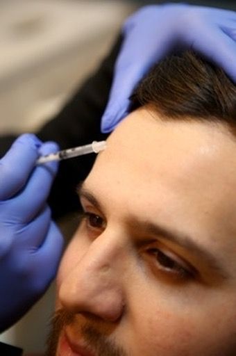 Crown Point male spa treatments model wearing a light brown jacket smiling