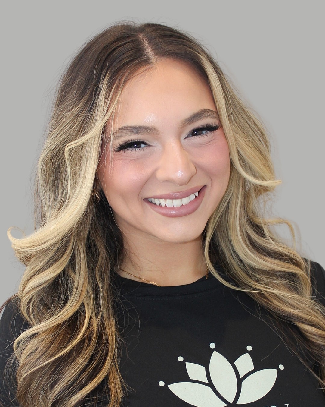 Smiling person with long, wavy blonde hair.