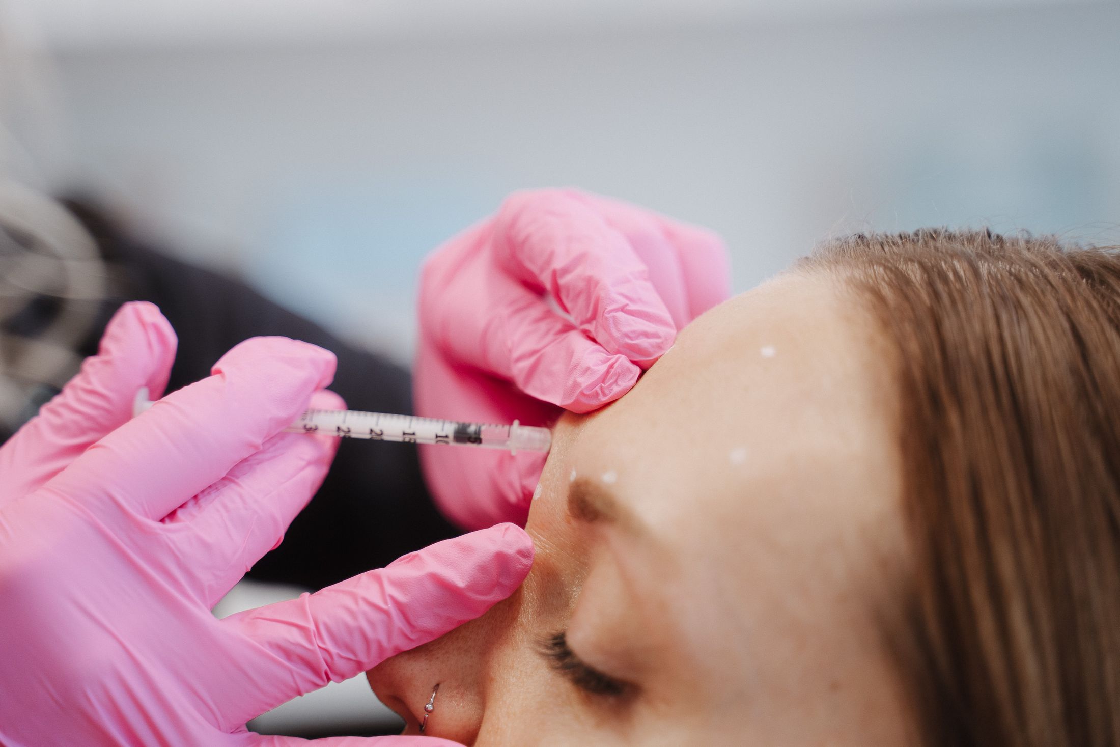 Crown Point Xeomin model in bed, resting her hand on her chin